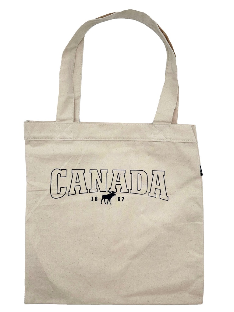 A light beige square tote bag with two handles at the top. Has a grain effect and Canada letters in all caps outlined with black in the center. Underneath there is 1867 with a small black moose in between the 8 and 6.