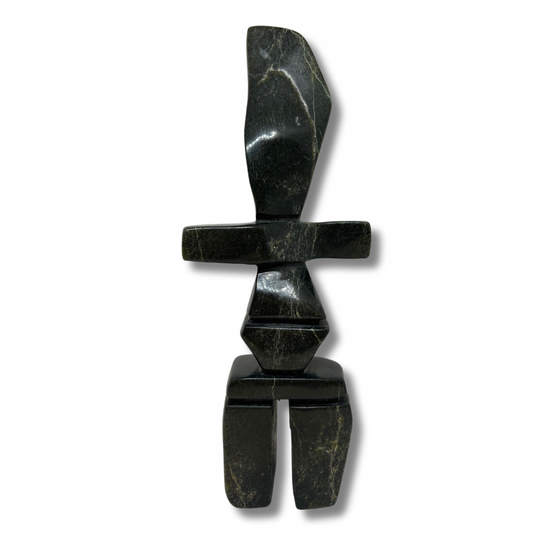 A tall, pear-shaped inukshuk carved from very dark green soapstone.