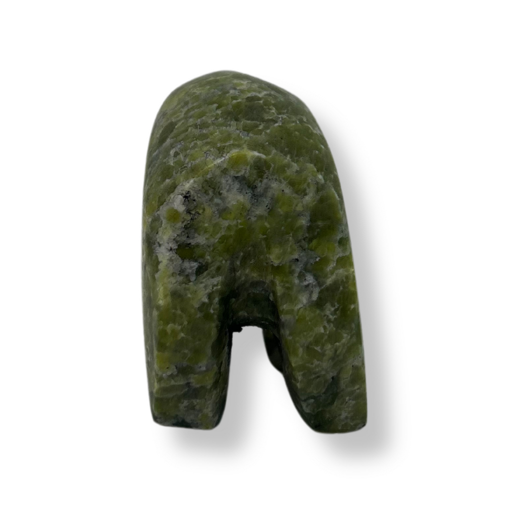 An inquisitive, bright green soapstone bear stands on all fours, head bowed as though examining something on the ground. This bear faces away.