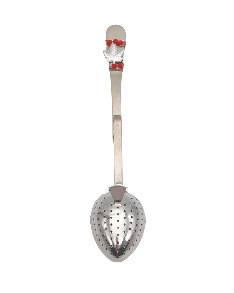 Metallic tea infuser with a small maple leaf and red beads at the top of the handle.