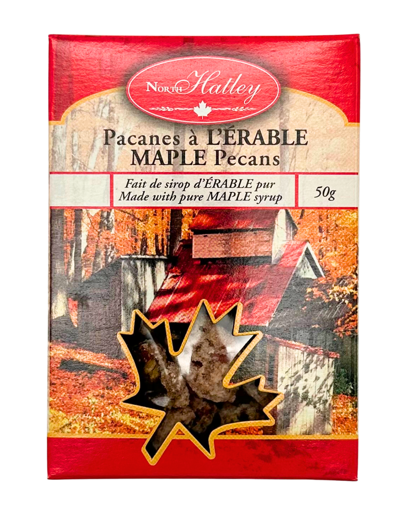 A small red box with the text "MAPLE Pecans" written on it in both English and French. Has a picture of a cabin in the forest with a maple leaf cut out with the pecans visible.