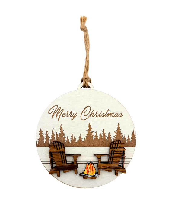 Round Christmas ornament with two chairs, a campfire, and 'Merry Christmas' text against a forest background.