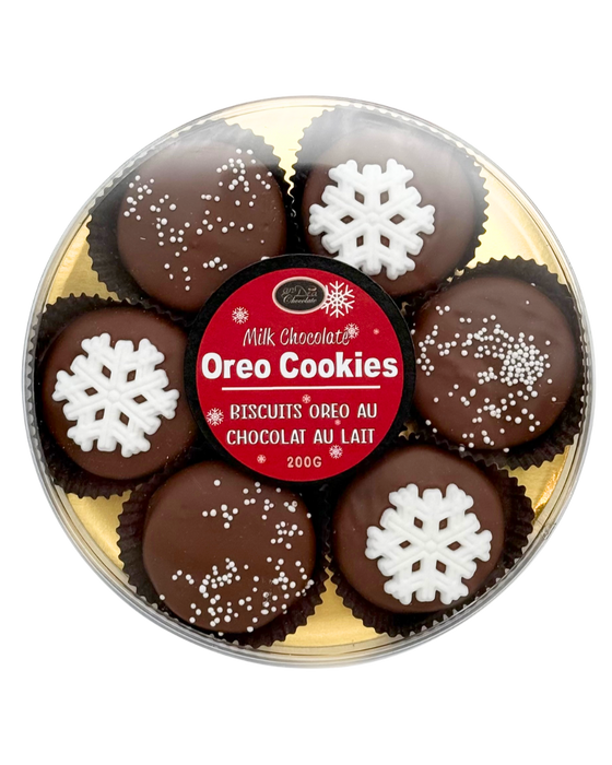 Milk chocolate Oreo cookies with snowflake decorations in a round tin.
