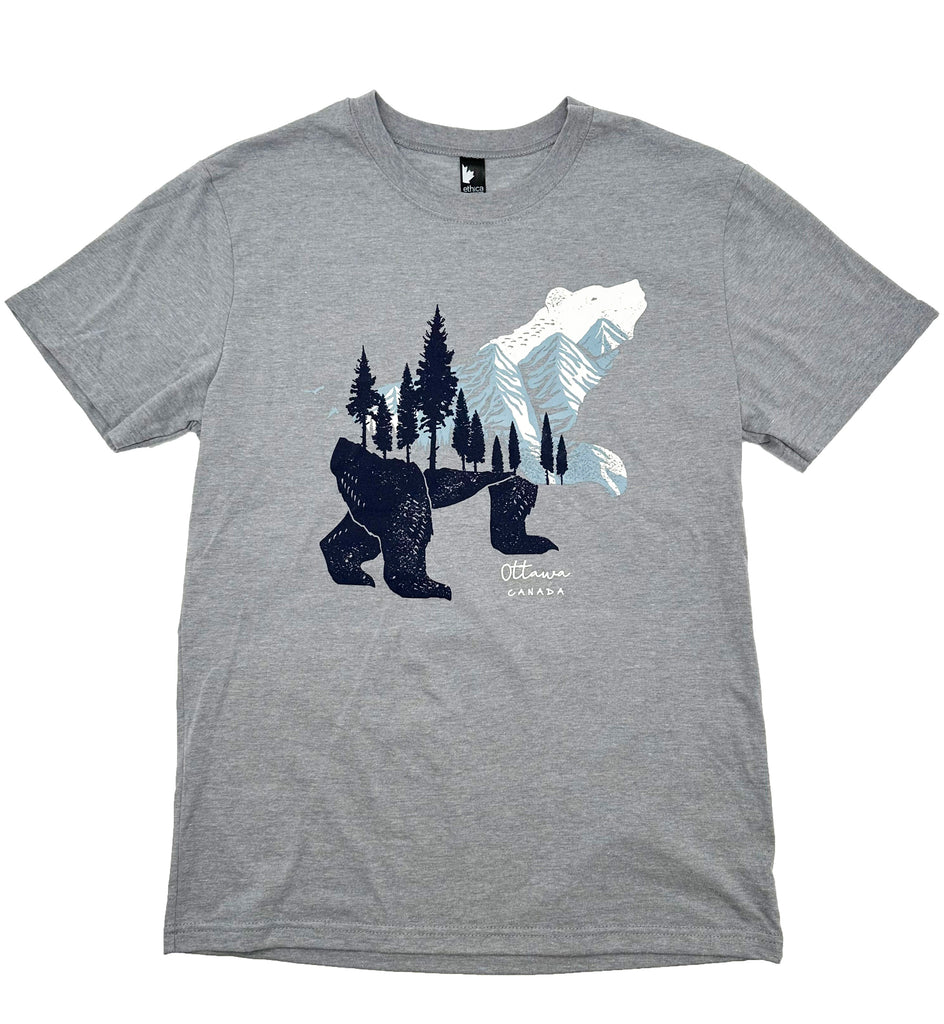 A grey shirt with a bear looking up. The bears head is white, the middle of the bears body is light blue and white mountains, and the bottom half is a navy ground with trees that go up into the mountains. Under the bears paw says Ottawa in cursive, with Canada in all caps underneath. Both texts are in white.