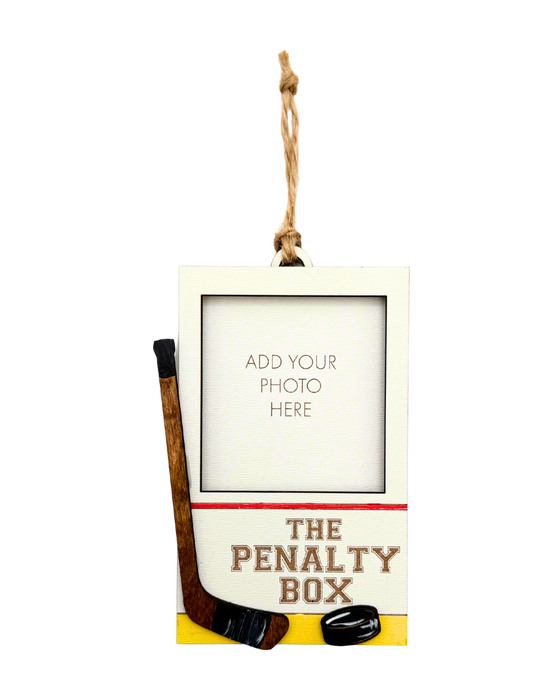 Hanging photo frame with hockey design labeled 'The Penalty Box'.