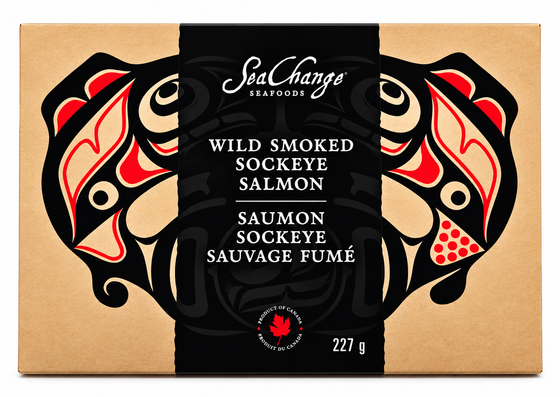 Picture features a single 227g smoked salmon travel pack. On the travel pack, Haida art of the Canadian pacific salmon by artist Don Yeomans is shown.