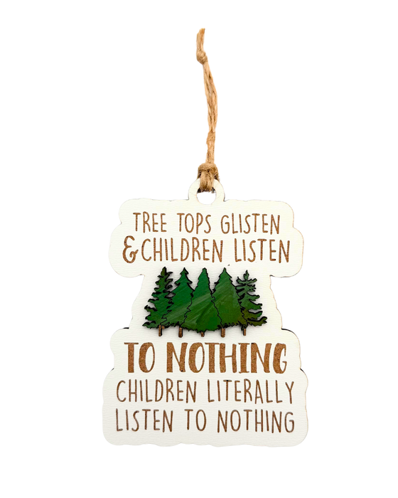 Wooden ornament with trees and text that reads 'Tree tops glisten & children listen to nothing children literally listen to nothing' with pine trees in the middle.