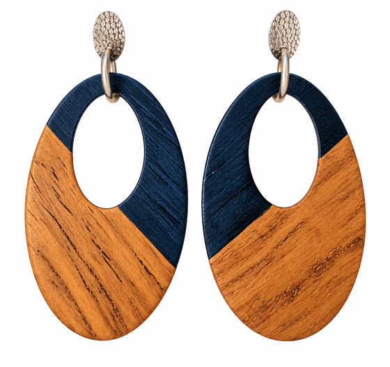 A pair of oval stud drop earrings with a cutout in the middle. The top half is blue and the bottom is walnut wood. Hardware is silver.