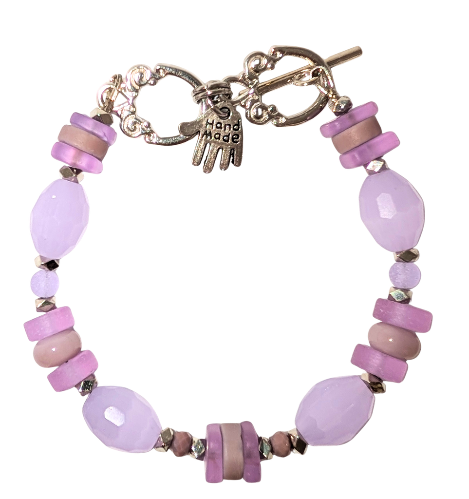 Bracelet with lavender sea glass, beads, and a small hand charm that says "handmade" between 2 rings for sizing. The clasp is a silver toggle clasp.