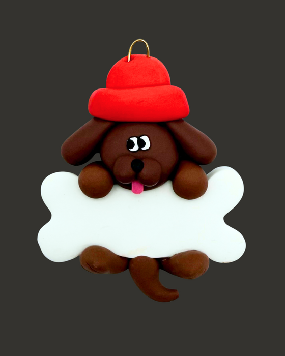 Brown dog ornament with a bone and a red hat on a gray background.