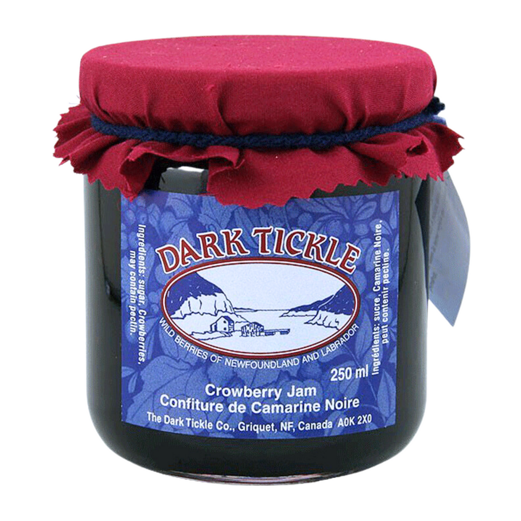 Glass Jar of Crowberry jam from Dark Tickle in Newfoundland. Jam is dark blue/purple in color, and shut sealed with a tin lid.