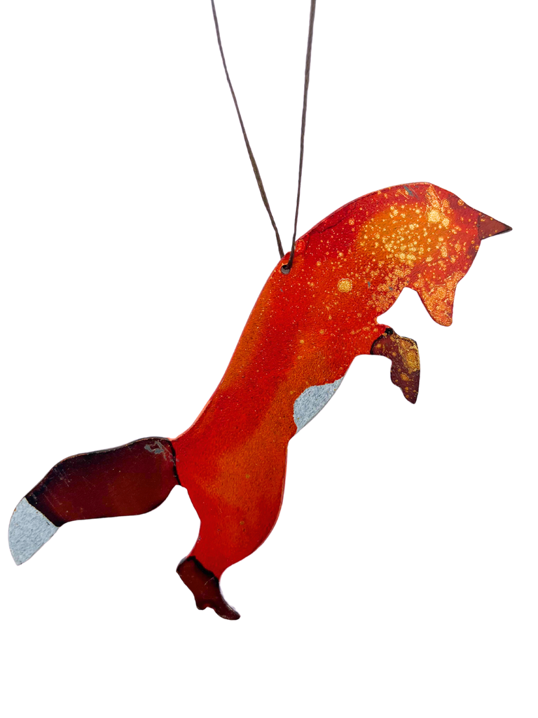 A leaping fox cut from steel and handpainted with bold red, brown, and gold.