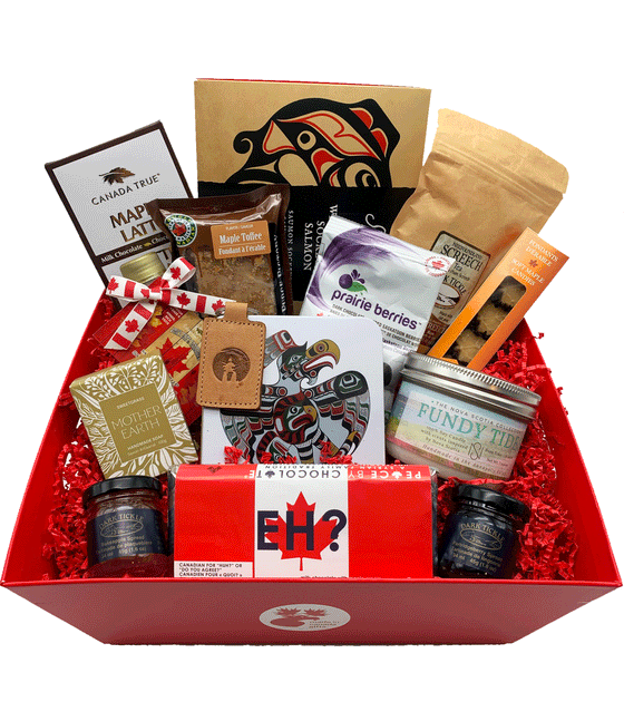 Assorted Canadian made Gift Basket with various items including First Nations made soap and Inuit made keychain, artisan food items including tea, chocolates, jams, and fudge, and a soy candle.