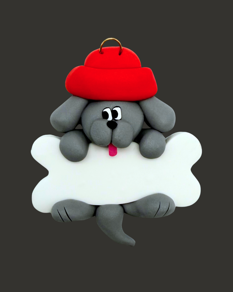 Grey dog ornament with a bone wearing a red hat on a black background.