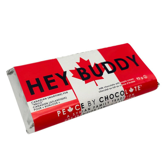 Silver foil wrapped chocolate bar. In a sleeve with a Canadian flag background with black lettering that says "Hey Buddy." Smaller text in bottom left corner says "Canadian (Maritime) for 'hello'."