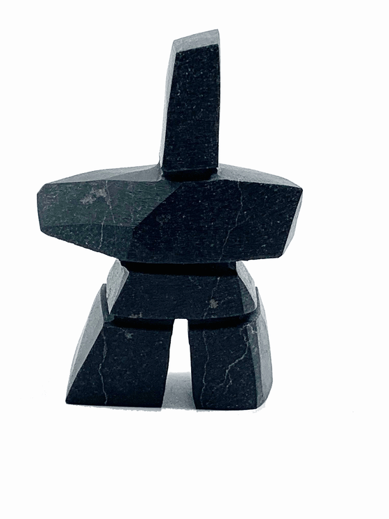An angular, tapered inukshuk carved in black stone.