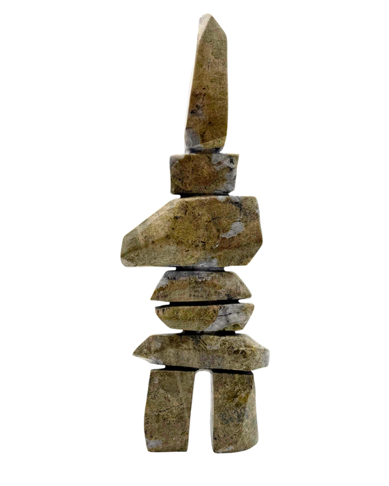 A tall inukshuk carved from greenish-brown stone.