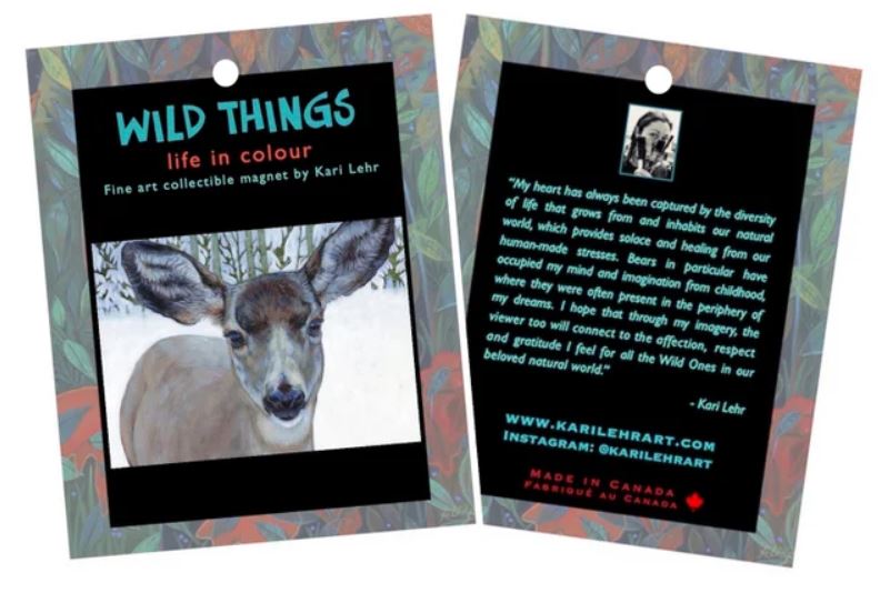 Magnet of Kari Lehr "Snow Angel" art print. Print image is a young deer in the snow. Magnet is on paper on with a colourful border and has "WILD THINGS" in blue on the front and a message from the artist on the back.