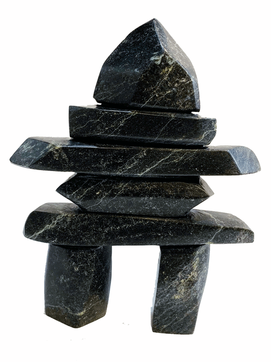 An inukshuk made of five slender slabs stacked on top of two broad legs and topped with a large head.