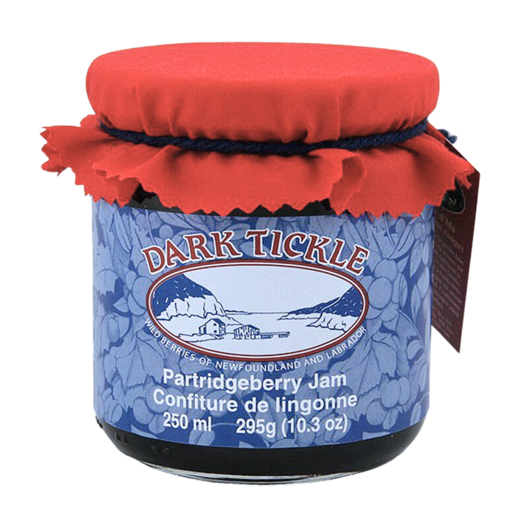 Glass Jar of Partridgeberry Jam from Dark Tickle in Newfoundland. Jam is dark blue/purple in color, and shut sealed with a tin lid.