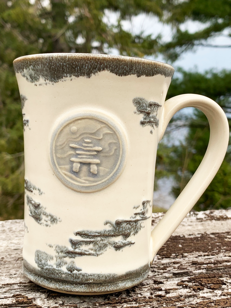 15 oz hand-thrown pottery mug with birch bark glaze and an inukshuk seal.