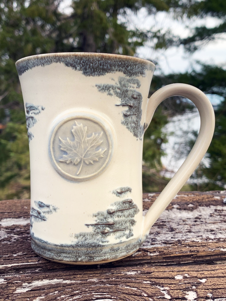 15 oz hand-thrown pottery mug with birch bark glaze and a maple leaf seal.