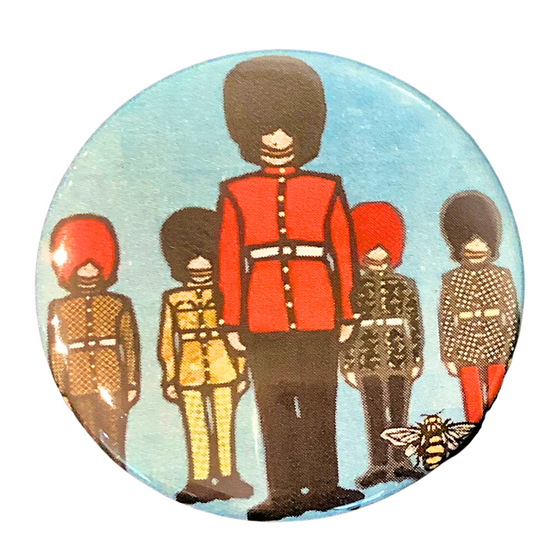 This magnet features an art print of five soldiers in ceremonial outfits. One soldier stands in the foreground, and the remaining four in the background. Each solider is wearing long pants, a belted jacket, and a tall beefeater hat. Each jacket has a unique, colourful print. At the bottom right of the picture is the artists mark—a small picture of a bee.