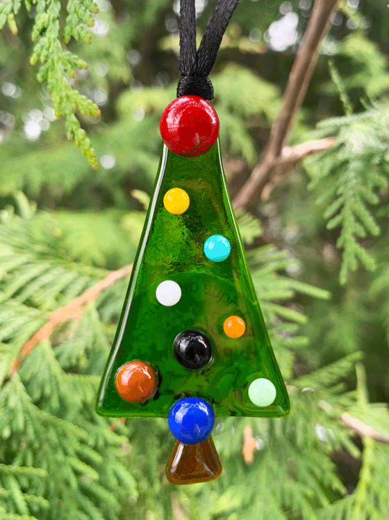 A Christmas tree fused glass ornament, made in Canada. The tree is green with colourful dots for decorations.