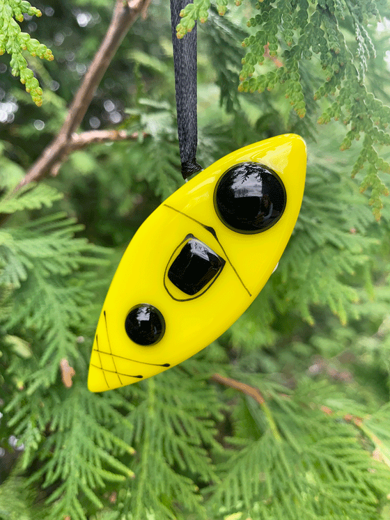 A beautiful kayak ornament that is Canadian made and made from fused glass. The kayak is bright green with black accents.