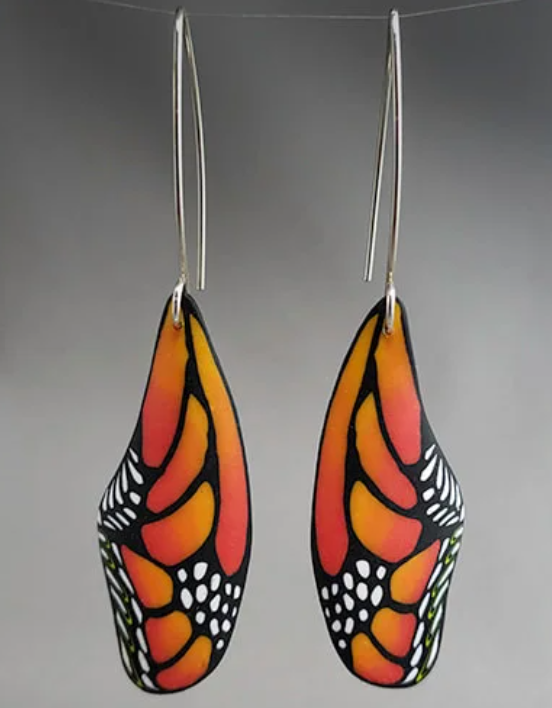 Butterfly wing-shaped earrings with orange, black, and white butterfly wing design.