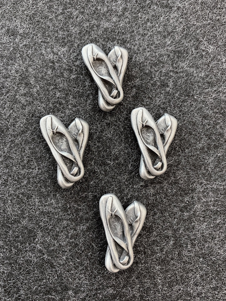 This magnets set includes four pairs of ballet slippers, each over lapped at the heel with a ribbon laying inside. 