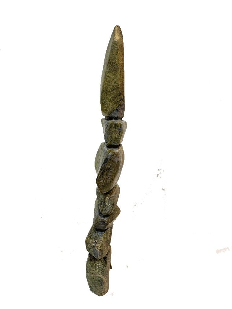 A tall inukshuk carved from greenish-brown stone.