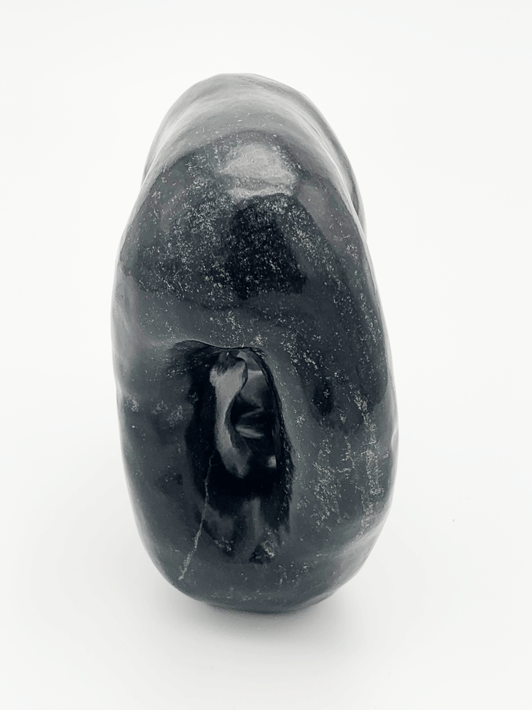 This carved black bear gazes thoughtfully at its reflection, also depicted in sculpture. The two bears stand on each other's four paws. This bear faces away.