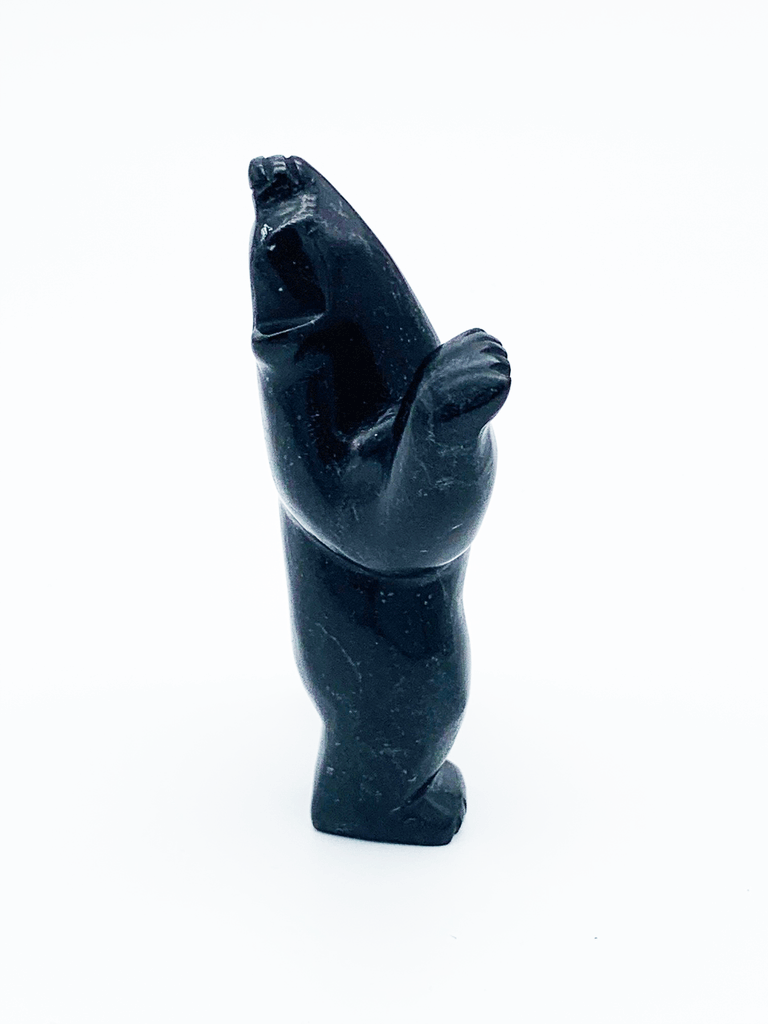 A dancing bear carved from jet black stone. This bear dances on one hind foot, with the other raised to one side and front paws raised. It throws its head back in jubilation. This bear faces right.