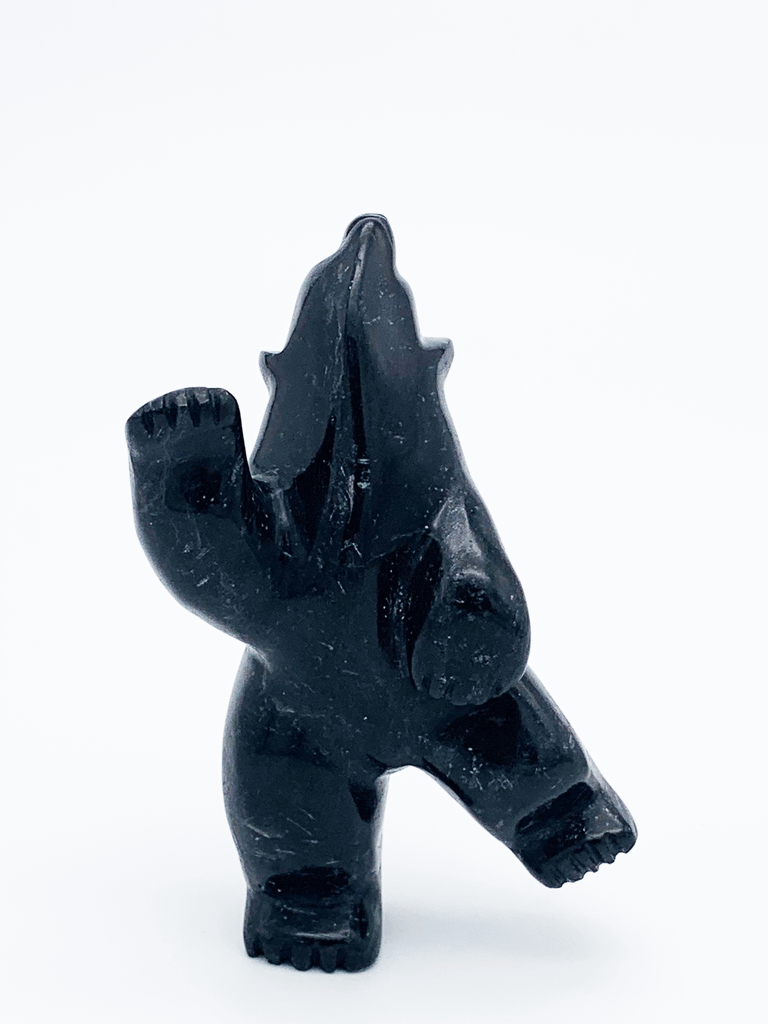A dancing bear carved from jet black stone. This bear dances on one hind foot, with the other raised to one side and front paws raised. It throws its head back in jubilation. This bear faces the viewer.