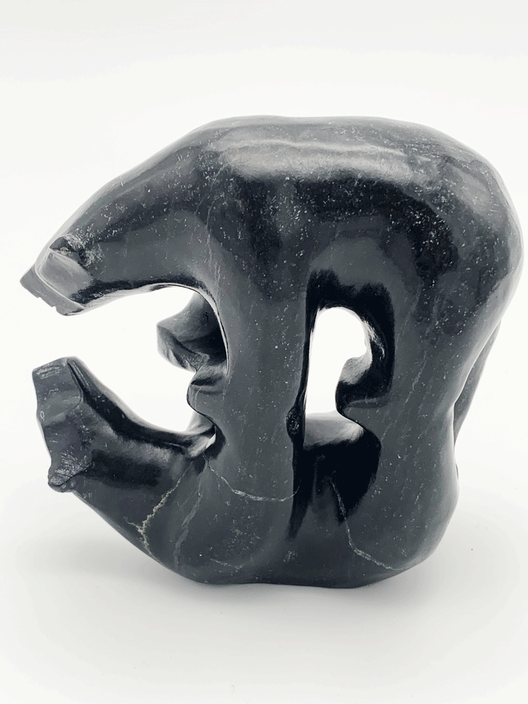 This carved black bear gazes thoughtfully at its reflection, also depicted in sculpture. The two bears stand on each other's four paws. This bear faces left.