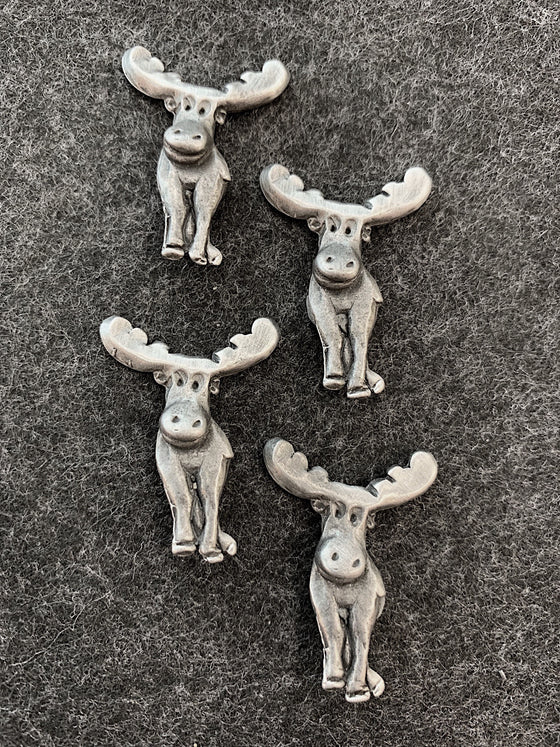 Four pewter magnets in the shape of smiling moose. 