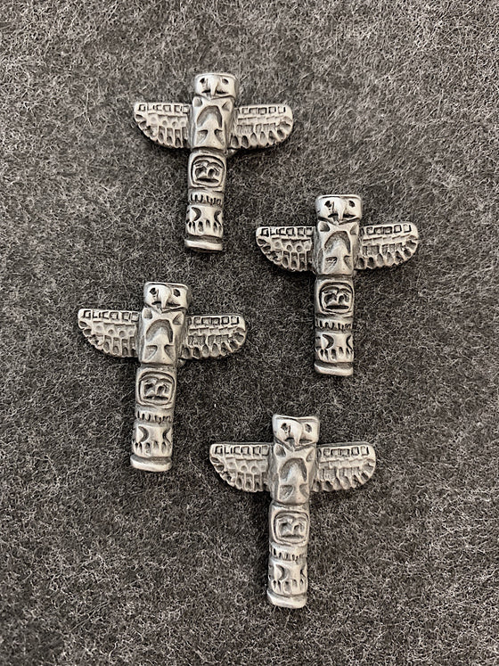 Four pewter magnets in the shape of totem poles featuring a bear and an eagle.