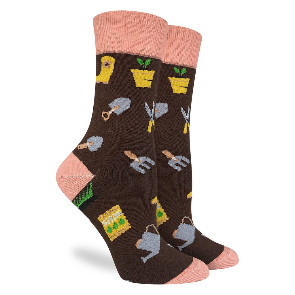 These fun socks feature gardening essentials such as shovels, rakes, and watering cans, as well as packets of seeds, a potted plant, and rubber boots on a brown background. The toe, heel and rim of these socks are a light peach colour. Spandex added to the 85% cotton blend gives the socks the perfect amount of stretch to hug your feet.
