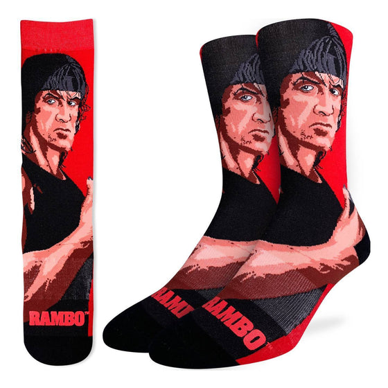 These fun socks feature a cartoon drawing of Sylvester Stallone from the 1982 movie Rambo giving a thumbs up, with the title written in red near the toe. The background of the sock is a bright red while the toe and heel are black. The active fit socks sport elastic arch bands to contour to your feet and provide support.