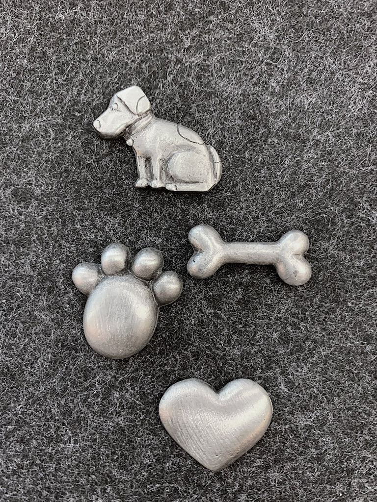 This pewter magnet set includes a dog, a paw print, a heart, and a bone. 