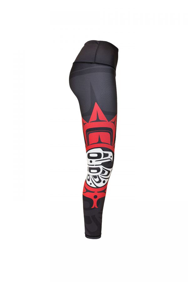 The eagle maple leaf leggings viewed from the right. This angle provides a clear view of the small red and white eagle maple leaf motif. It contrasts strongly against the dark background.