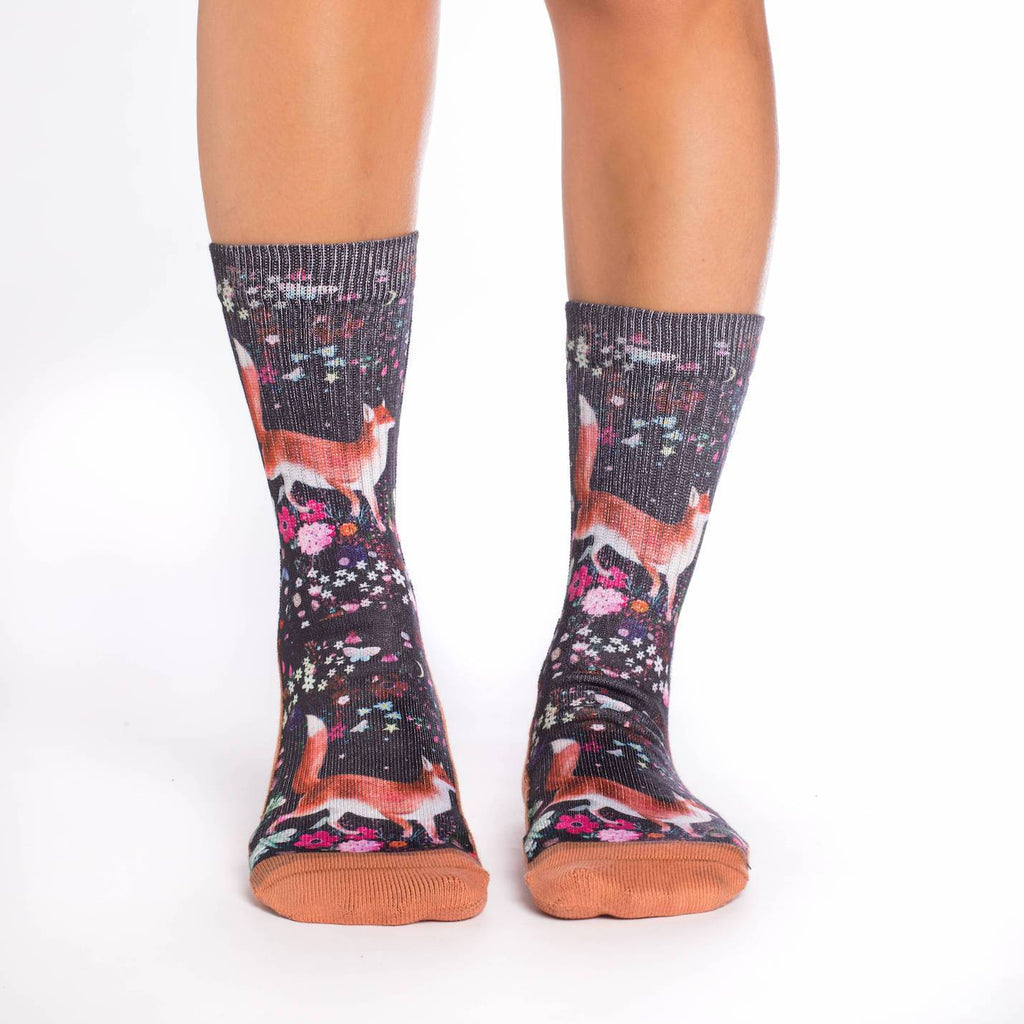 These fun socks feature beautiful red foxes walking among a field of brightly coloured flowers and butterflies. Behind the foxes and flowers is a black background, and the sole, toe, heel, and rim of the sock are a light brown. The active fit socks sport elastic arch bands to contour to your feet and provide support. 