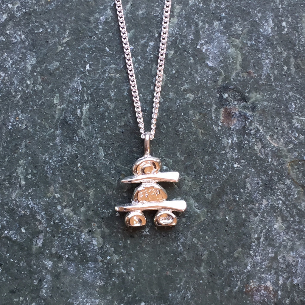 A handmade, sterling silver Inukshuk hanging from a fine silver chain. 