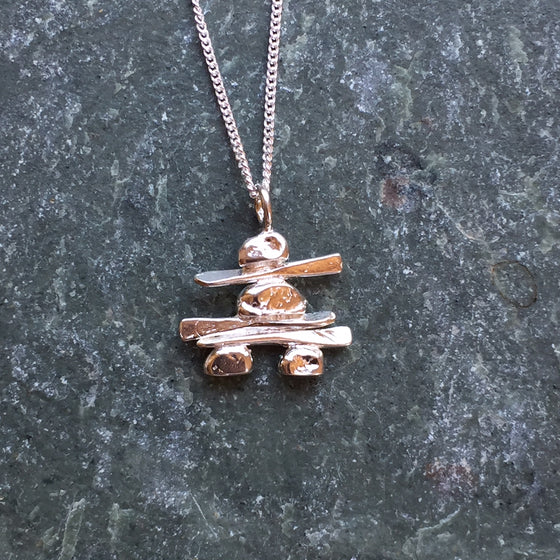 A handmade, sterling silver Inukshuk hanging from a fine silver chain. 