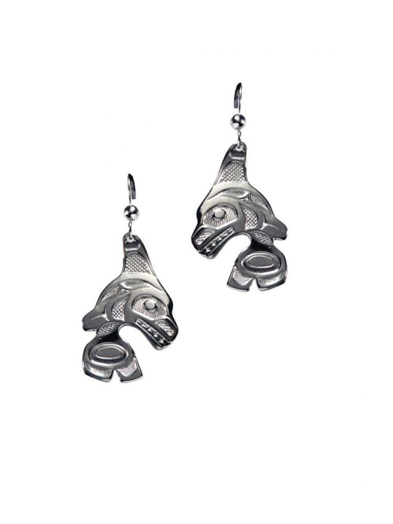 Two silvery earrings with Haida designs of orcas jumping.