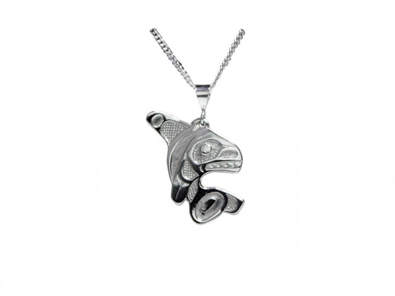 A silvery pendant with Haida designs of an orca jumping.
