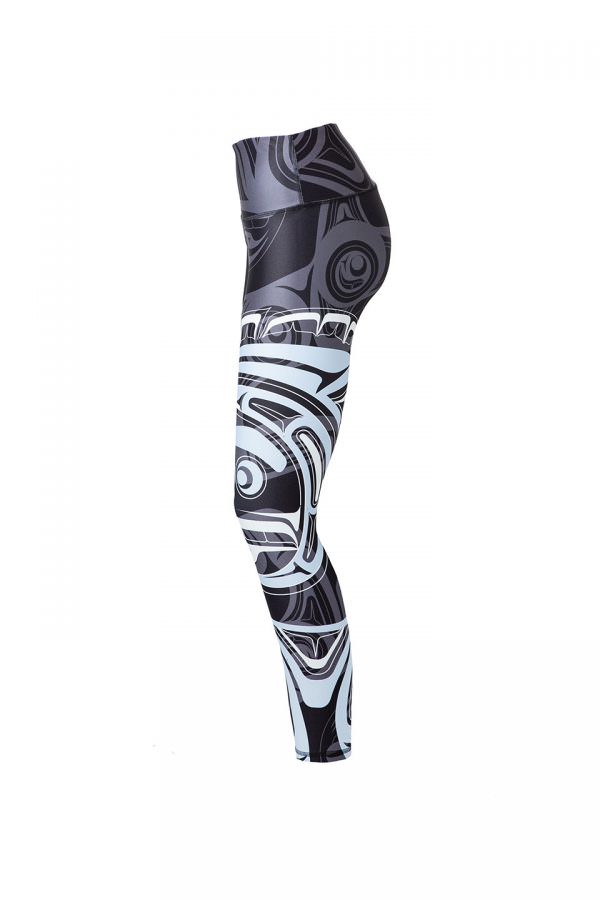 The wolf moon leggings viewed from the left. This angle provides a view of the moon’s eye and mouth near the knee of the leggings. The grey wolf’s eye and ear can be seen on the hip.