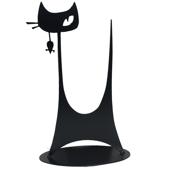 This metal sculpture shows the matte black silhouette of a highly stylized cat. It has a tall thin tail and large head on a tall thin neck. It has two whiskers and a single, cunning right eye.  A small mouse dangles from the cat’s mouth. The piece stands on a oval base.