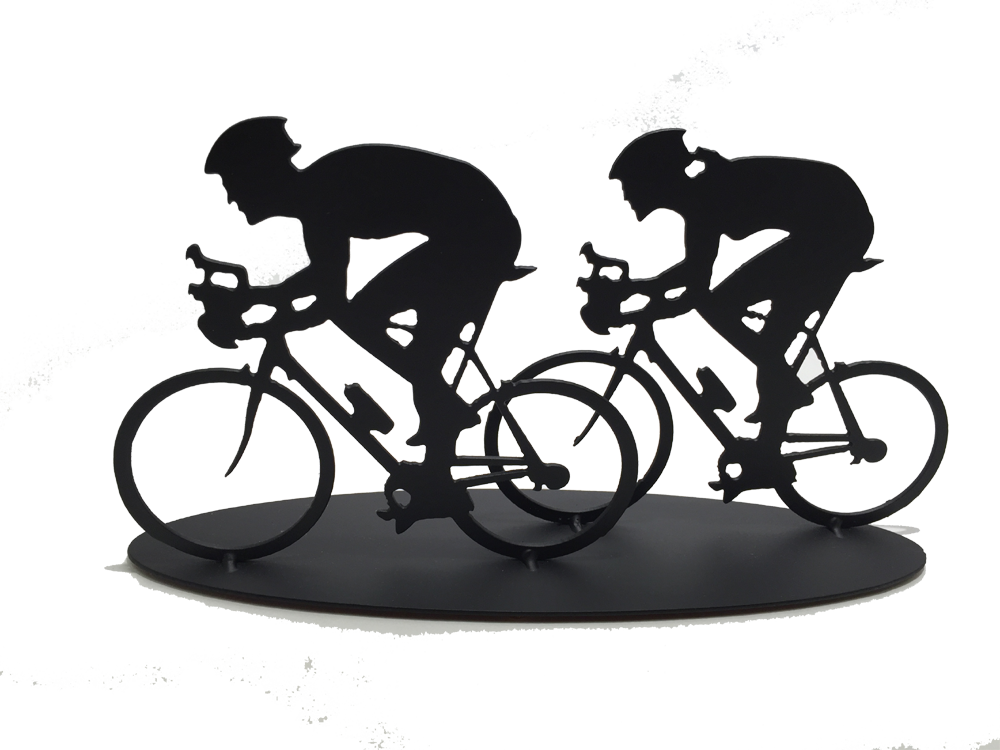 This metal sculpture shows the matte black silhouette a male and female cyclist riding together. The female cyclist is to the right and slightly behind the male. Both are hunched forward over their handle bars. The bikes are slightly simplified, and the wheels have no spokes. This piece sits on an oval base.